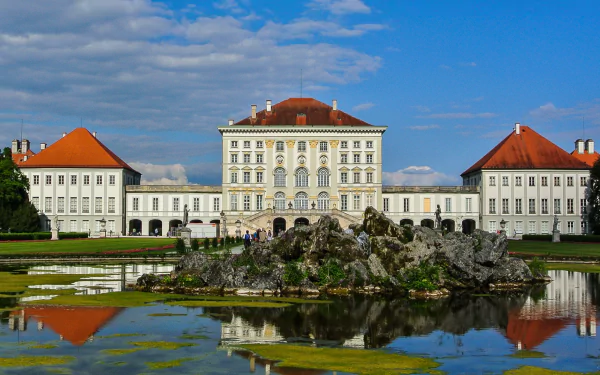 Man-made Nymphenburg Palace with Baroque wings and central dome reflected in a pond — 2K Quad HD PC desktop wallpaper/background.