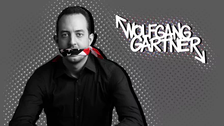 HD desktop wallpaper: black-and-grey dotted background, a man in a black shirt with American-flag tape over his mouth, bold graffiti text, electronic/pop music aesthetic.