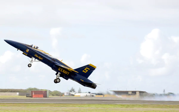 Blue Angels McDonnell Douglas F/A-18 Hornet jet from the U.S. Navy takes off during an air show, captured in HD as a desktop wallpaper background.