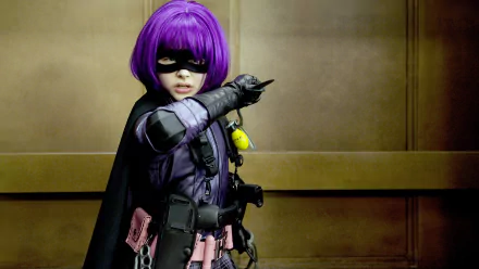 Hit-Girl, portrayed by Chloë Grace Moretz in the movie Kick-Ass, strikes a fierce pose in this vibrant 4K Ultra HD desktop wallpaper, showcasing her signature purple costume and weapons.