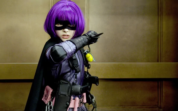 Hit-Girl, portrayed by Chloë Grace Moretz in the movie Kick-Ass, strikes a fierce pose in this vibrant 4K Ultra HD desktop wallpaper, showcasing her signature purple costume and weapons.