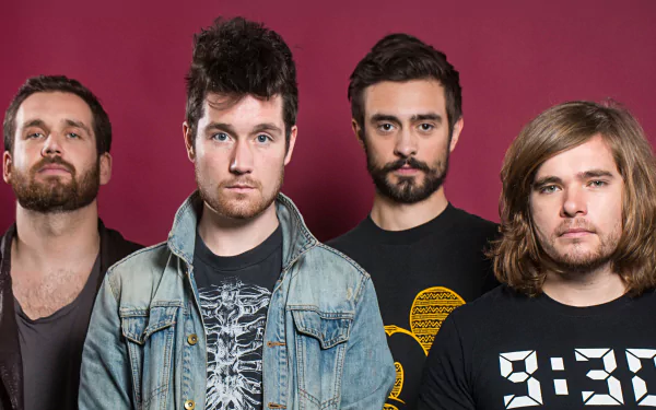 HD desktop wallpaper featuring the English rock band Bastille posing against a solid red background.