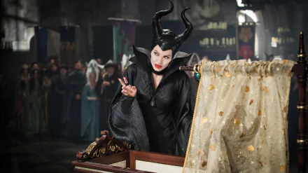 Angelina Jolie as Maleficent in a dramatic scene, showcasing her iconic horned costume and striking makeup, set against an enchanting backdrop from the movie. 4K Ultra HD quality.