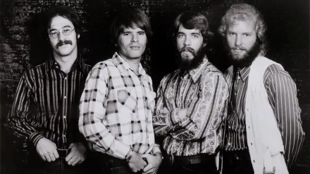 Black and white HD desktop wallpaper featuring the members of Creedence Clearwater Revival posing together in patterned shirts and vests.