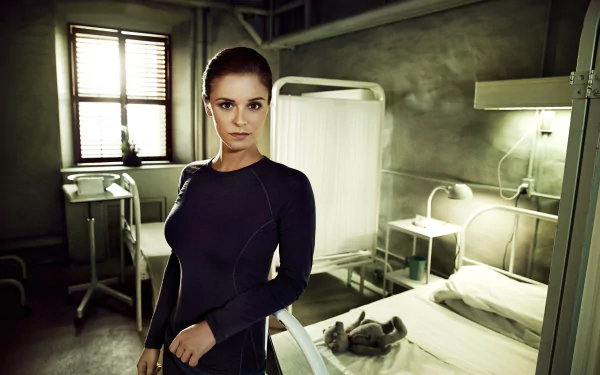 HD desktop wallpaper featuring a woman in a blue outfit standing confidently in a dimly lit room with medical equipment, tagged with Helix.
