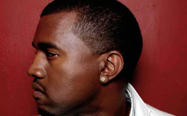 A striking HD wallpaper featuring Kanye West, showcasing his profile against a bold red background, capturing the essence of his presence in the music scene.