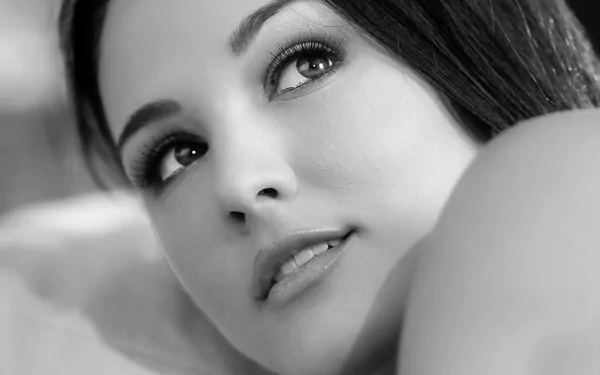 Black and white HD desktop wallpaper featuring a close-up of a woman's face with an expressive look in her eyes, exuding elegance and serenity.