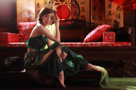 A Taiwanese woman, Mikako Zhang Kaijie, dressed in a traditional skirt, sits gracefully on a sofa with pillows, creating an elegant HD desktop wallpaper and background.
