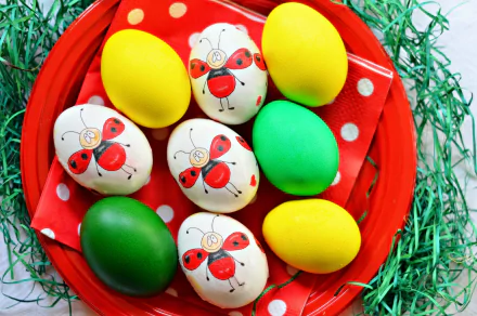 HD PC desktop wallpaper featuring colorful Easter eggs, including yellow, green, and white eggs decorated with red ladybug designs on a red plate with green grass.
