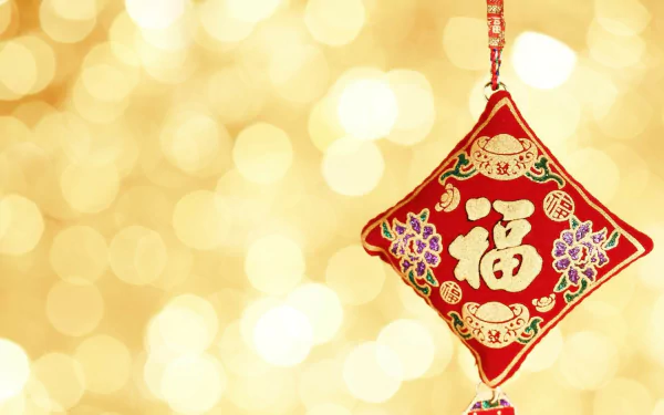 HD PC desktop wallpaper featuring a red Chinese New Year hanging ornament with gold characters and floral designs against a sparkling golden bokeh background.