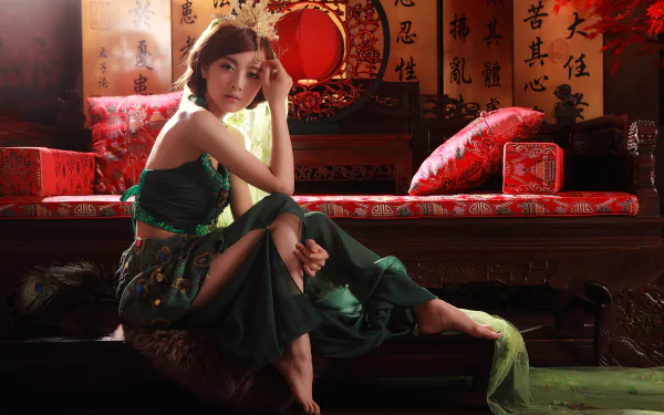 A Taiwanese woman, Mikako Zhang Kaijie, dressed in a traditional skirt, sits gracefully on a sofa with pillows, creating an elegant HD desktop wallpaper and background.