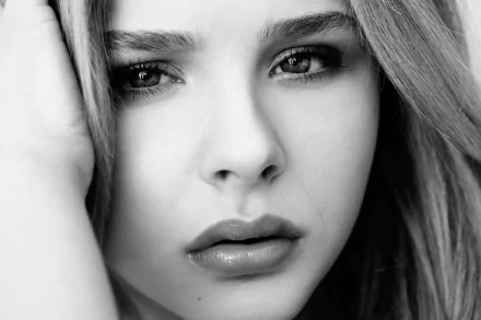 Black-and-white HD desktop wallpaper featuring a close-up portrait of celebrity Chloë Grace Moretz with a thoughtful expression.