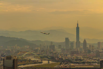 4K Ultra HD wallpaper featuring an airplane flying over Taipei's cityscape with mountains in the background, highlighting Taiwan's blend of man-made and natural beauty.