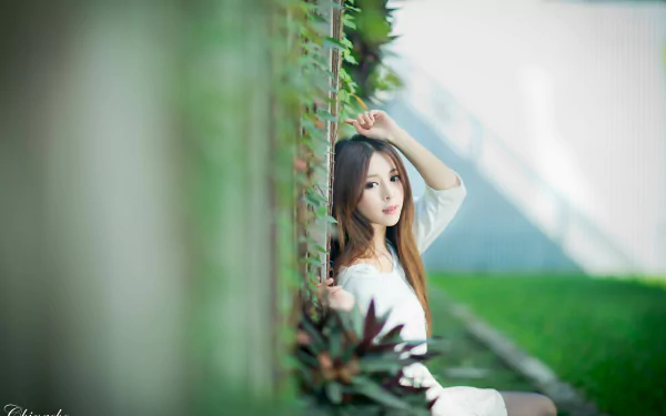A Taiwanese woman, Julie Chang (Zhang Qi Jun), poses thoughtfully by a fence with soft bokeh effects in a vibrant 4K Ultra HD desktop wallpaper.