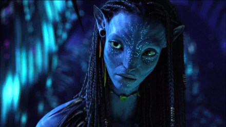 HD PC desktop wallpaper featuring a close-up of a Na'vi character from the movie Avatar with glowing blue markings in a dark, bioluminescent forest setting.