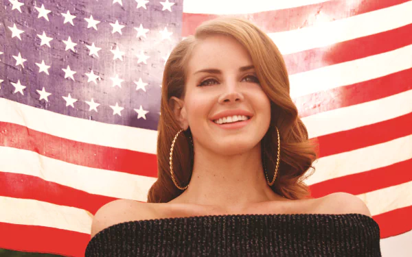 Lana Del Rey smiling in front of a waving American flag, captured in a vibrant 4K Ultra HD music-themed desktop wallpaper.