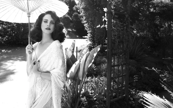 Black-and-white HD PC desktop wallpaper of Lana Del Rey holding a parasol, surrounded by lush garden foliage, evoking a vintage, cinematic music vibe.