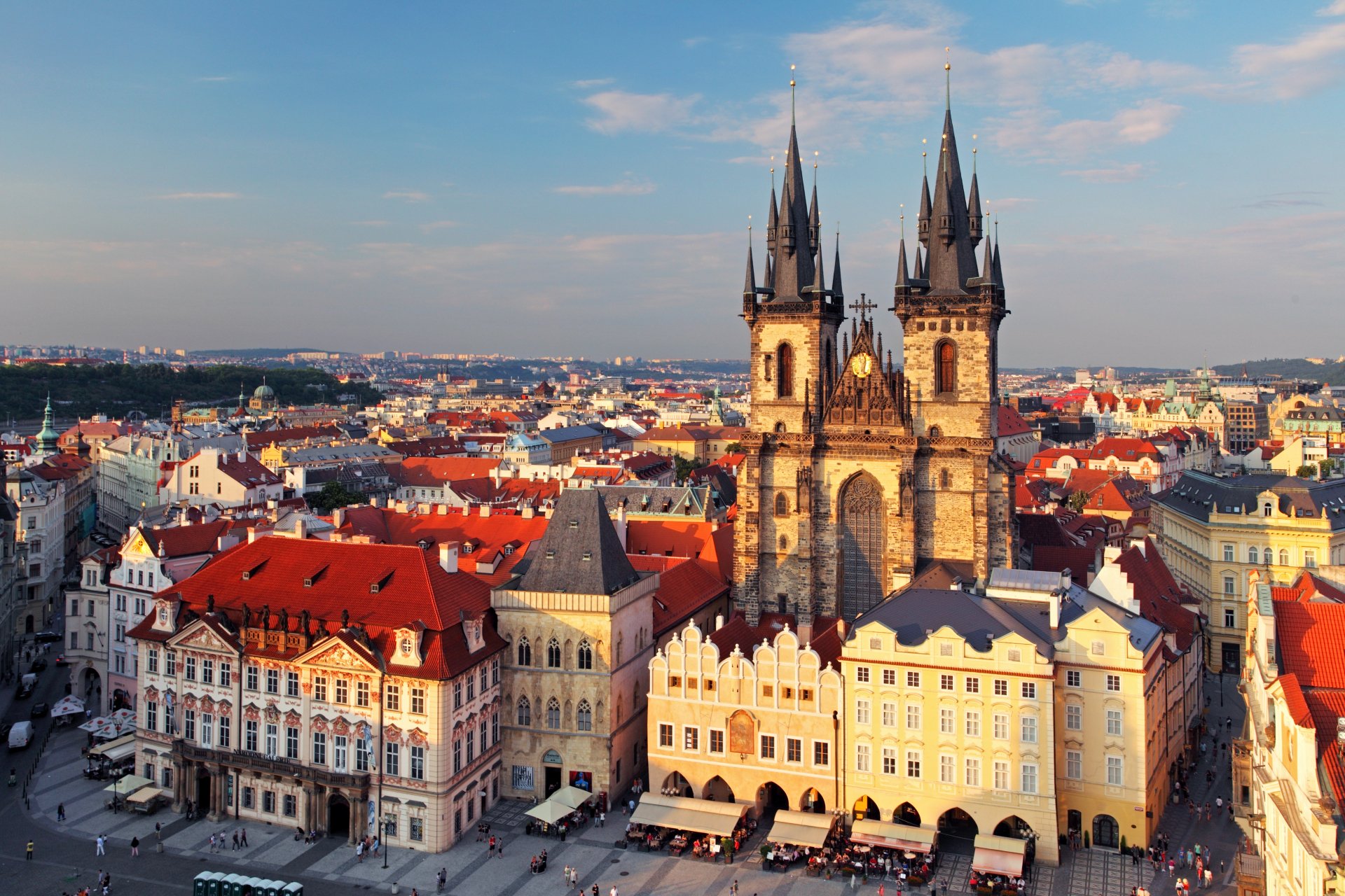 A vibrant 4K cityscape of Prague's Old Town Square featuring the Gothic Tyn Church and colorful historic houses under a clear sky.