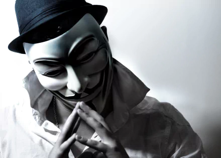 HD desktop wallpaper featuring an anonymous figure wearing a Guy Fawkes mask and a fedora, symbolizing technology and anonymity.