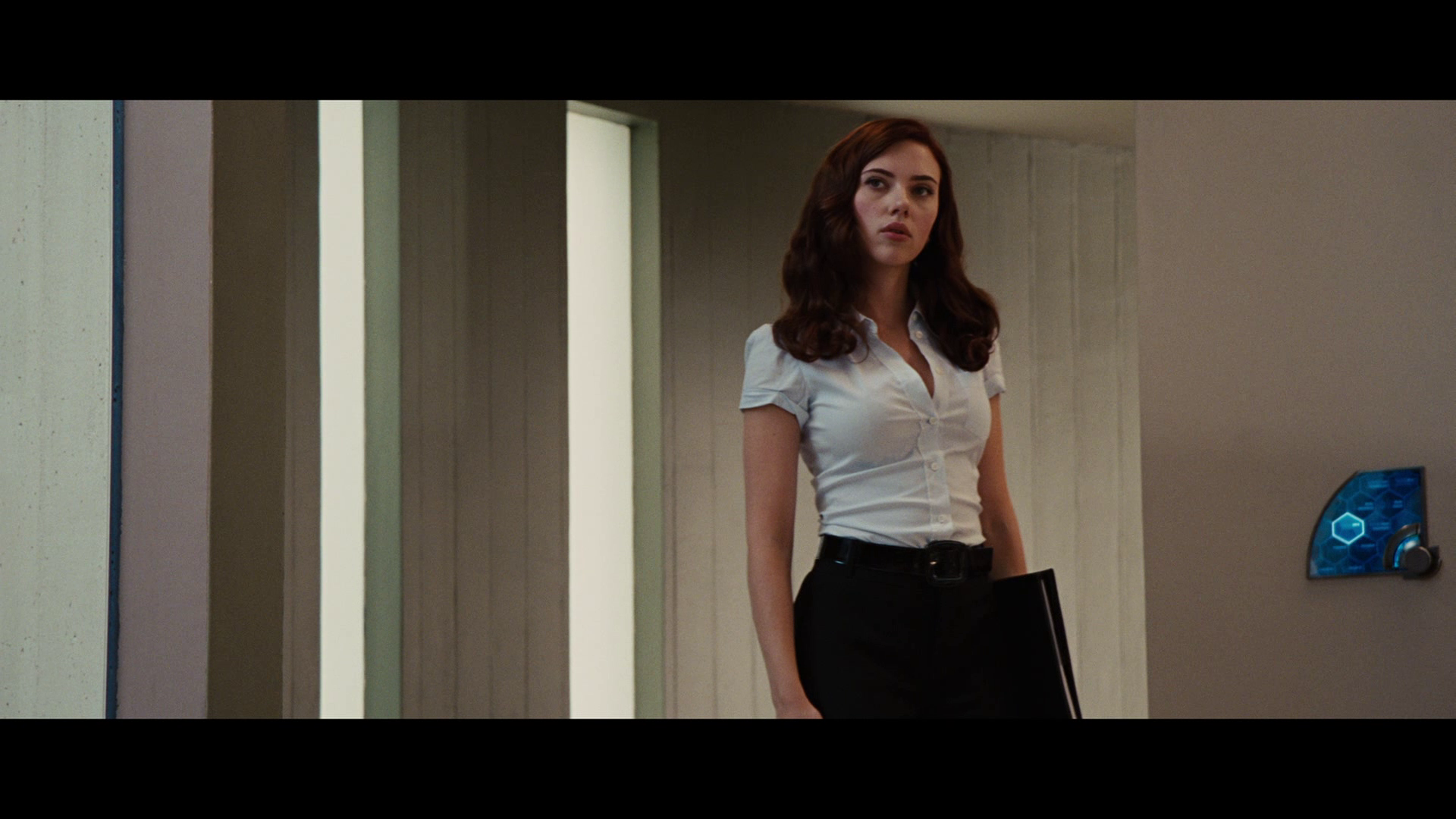 HD PC desktop wallpaper featuring a scene from the movie Iron Man 2, showing a woman standing in a modern interior setting.