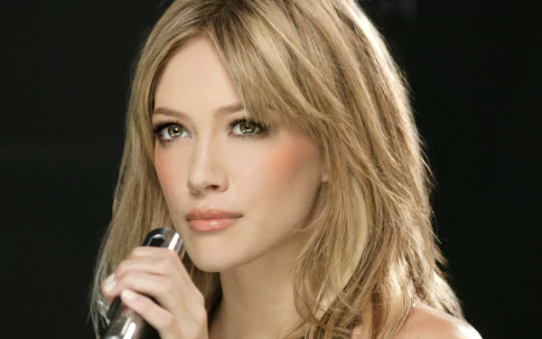 Close-up of an unidentified blonde woman holding a microphone, soft makeup and glossy lips against a dark backdrop — 4K Ultra HD PC desktop wallpaper/background.