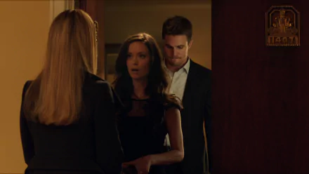 Isabel Rochev, portrayed by Summer Glau, and Stephen Amell in a dramatic scene from the TV show Arrow. The image captures a tense moment in a stylish setting.