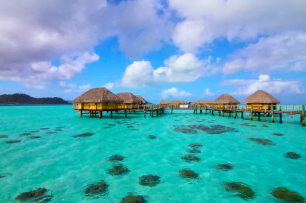 Overwater bungalows on turquoise waters in Tavaiora, Tahiti, French Polynesia, showcasing a tropical paradise captured in 4K Ultra HD photography.