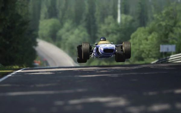 Blue Lotus 49 racing car airborne on a sunlit forest track in Assetto Corsa — 2K Quad HD PC desktop wallpaper of classic open-wheel racing.