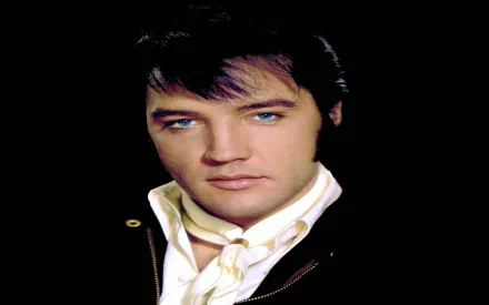 Elvis Presley, renowned music icon, gazes intensely in this high-definition desktop wallpaper, showcasing his signature style and striking blue eyes against a dark background.
