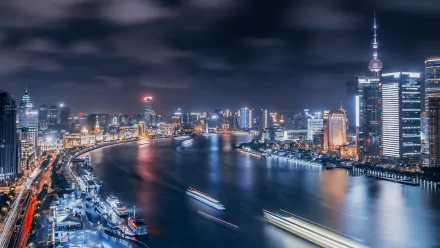 A stunning view of Shanghai's Huangpu River at night, showcasing the vibrant city skyline and man-made lights reflecting on the water, captured in 4K Ultra HD resolution.