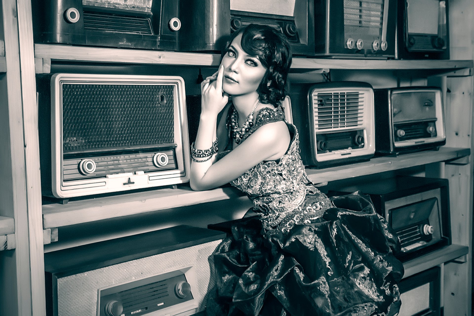 Vintage-style HD desktop wallpaper featuring a woman in retro attire posing beside an array of classic radios.