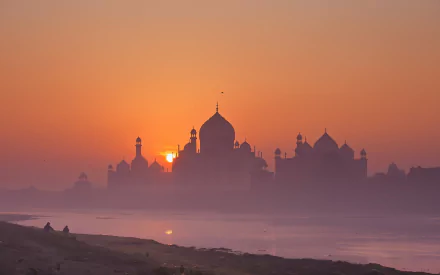 HD desktop wallpaper showing the Taj Mahal at sunset in Agra, India. The stunning silhouette of the palace is beautifully highlighted against the vibrant sky.
