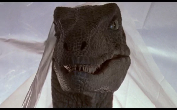 A close-up of a dinosaur from the movie Jurassic Park, showcasing its fierce expression, set against a soft background, ideal as an HD PC desktop wallpaper and background.