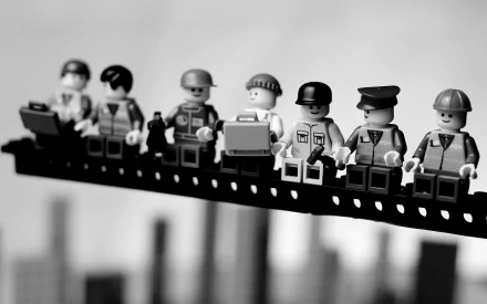 A black-and-white HD desktop wallpaper featuring a row of Lego figurines in various professions, showcasing a creative and whimsical man-made scene.