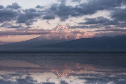 5K Ultra HD desktop wallpaper of Mount Fuji volcano in Shizuoka Prefecture at sunrise, cloud-wreathed peak reflected on calm water — nature scene, Japan.