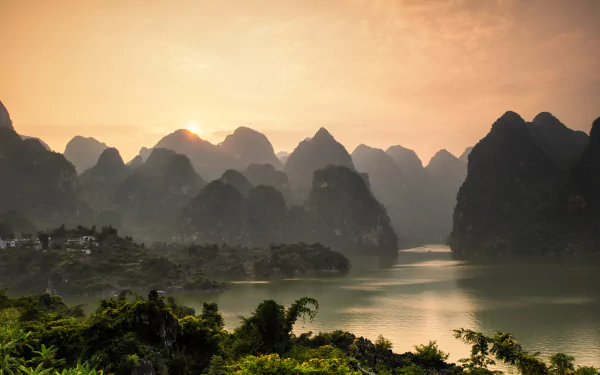 A stunning sunset over the Li River, framed by the majestic Nanling Mountains in Guangxi Zhuang, China. A breathtaking landscape showcasing nature's beauty.