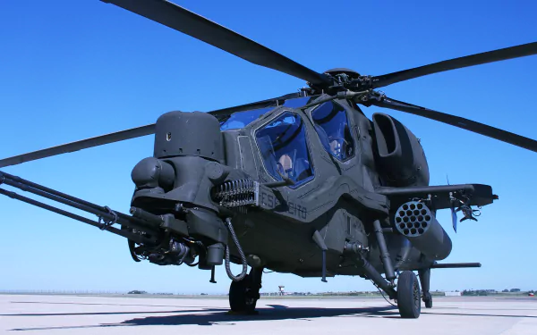 Agusta A129 Mangusta military attack helicopter on a tarmac against a clear blue sky, high-resolution 2K Quad HD aircraft/helicopter PC desktop wallpaper background.