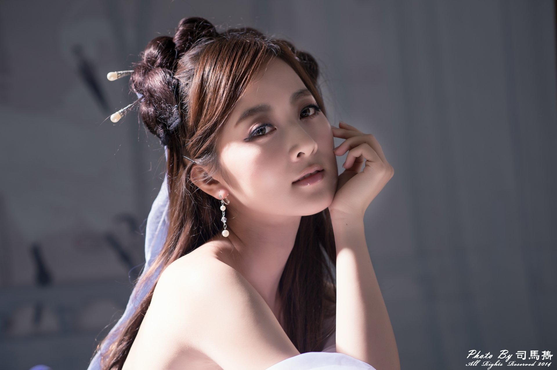 Soft-lit 4K Ultra HD desktop wallpaper: elegant woman with earrings, an ornate hairpin and traditional hair-dress, gazing softly toward the viewer.