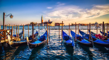 Sunset view over Venice's Grand Canal with gondolas moored along the water, captured in stunning 4K Ultra HD for a vivid PC desktop wallpaper.