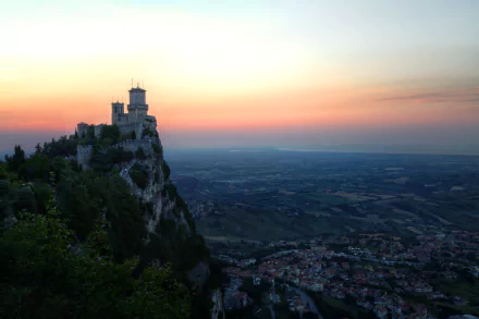 Fortress of Guaita, man-made stronghold on Monte Titano at sunset, evening sky over Borgo Maggiore and San Marino — 5K Ultra HD desktop wallpaper.
