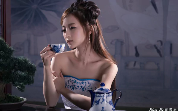 A Taiwanese woman in traditional Chinese dress, styled hair, holding a tea cup beside an ornate blue and white tea set, captured in 4K Ultra HD wallpaper quality.
