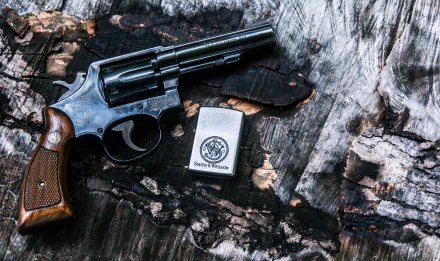 A detailed view of a Smith & Wesson .38 Special revolver resting on textured wood, accompanied by a branded metal lighter, showcased in vibrant 4K Ultra HD quality.