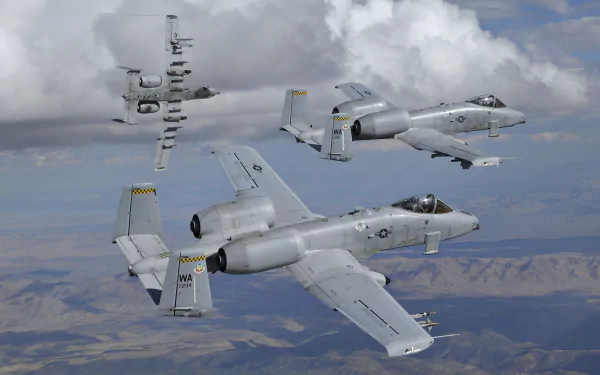 Three Fairchild Republic A-10 Thunderbolt II warplanes navigate through a cloudy sky, showcasing their military design in this striking 4K Ultra HD wallpaper.