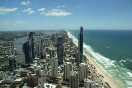 Aerial 5K Ultra HD PC desktop background of Gold Coast, Queensland, Australia: oceanfront cityscape with man-made skyscrapers, sandy beach and the Pacific Ocean stretching to the horizon.