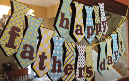 Colorful tie-shaped banner spelling out Happy Father's Day hangs as a festive decoration in a home, captured in a high-definition Father's Day holiday desktop wallpaper.