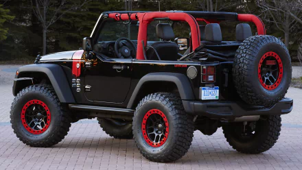 A stylish Jeep Wrangler Level Red, featuring a bold black exterior with red accents, stands ready for adventure. This rugged 4x4 vehicle embodies off-road capability.