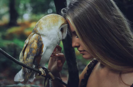A serene moment between a blonde woman and a barn owl in nature, creating a captivating mood. This HD image serves as an enchanting desktop wallpaper.