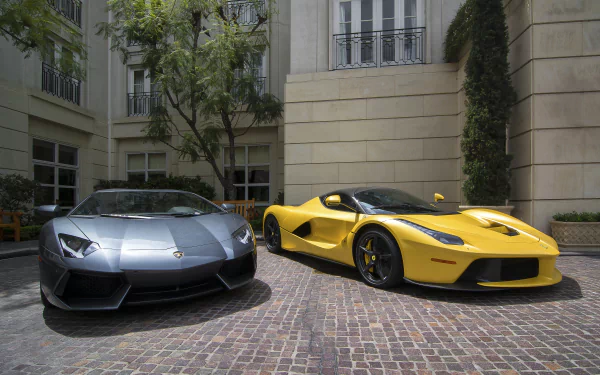 A striking HD wallpaper featuring a silver Lamborghini Aventador and a yellow Ferrari LaFerrari parked together, showcasing these stunning supercars in an elegant setting.