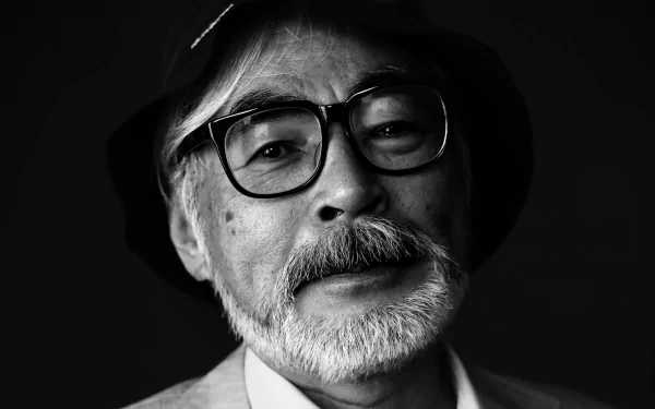 Black and white HD wallpaper of a bespectacled man with a hat, reminiscent of Hayao Miyazaki, providing an elegant background.