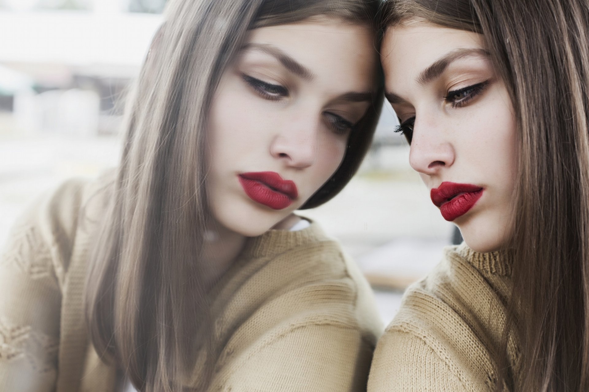 A brunette woman with brown eyes and red lipstick gazes intently at her reflection, captured in a high-definition PC desktop wallpaper.